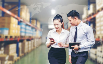 Asian Business man and Business woman worker in warehouse  using tablet checking boxes Logistic import and export concept